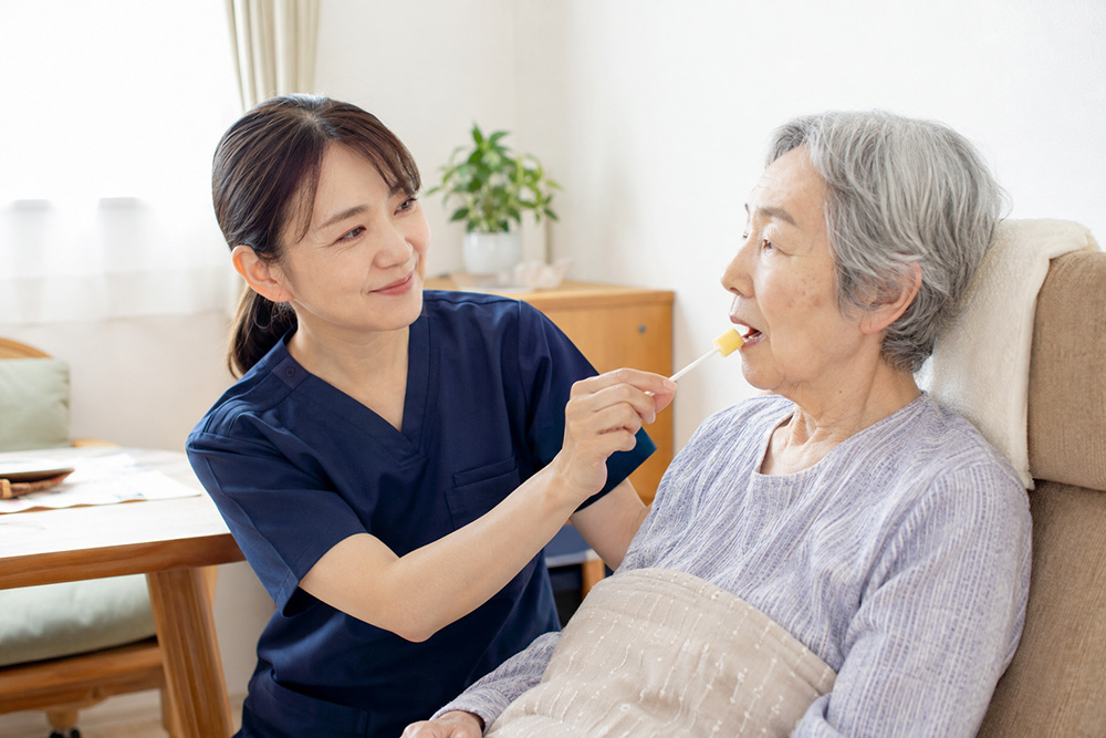 医療・看護・介護の専門職が、療養者の様子を確かめながら日常的な口腔ケアを行う様子